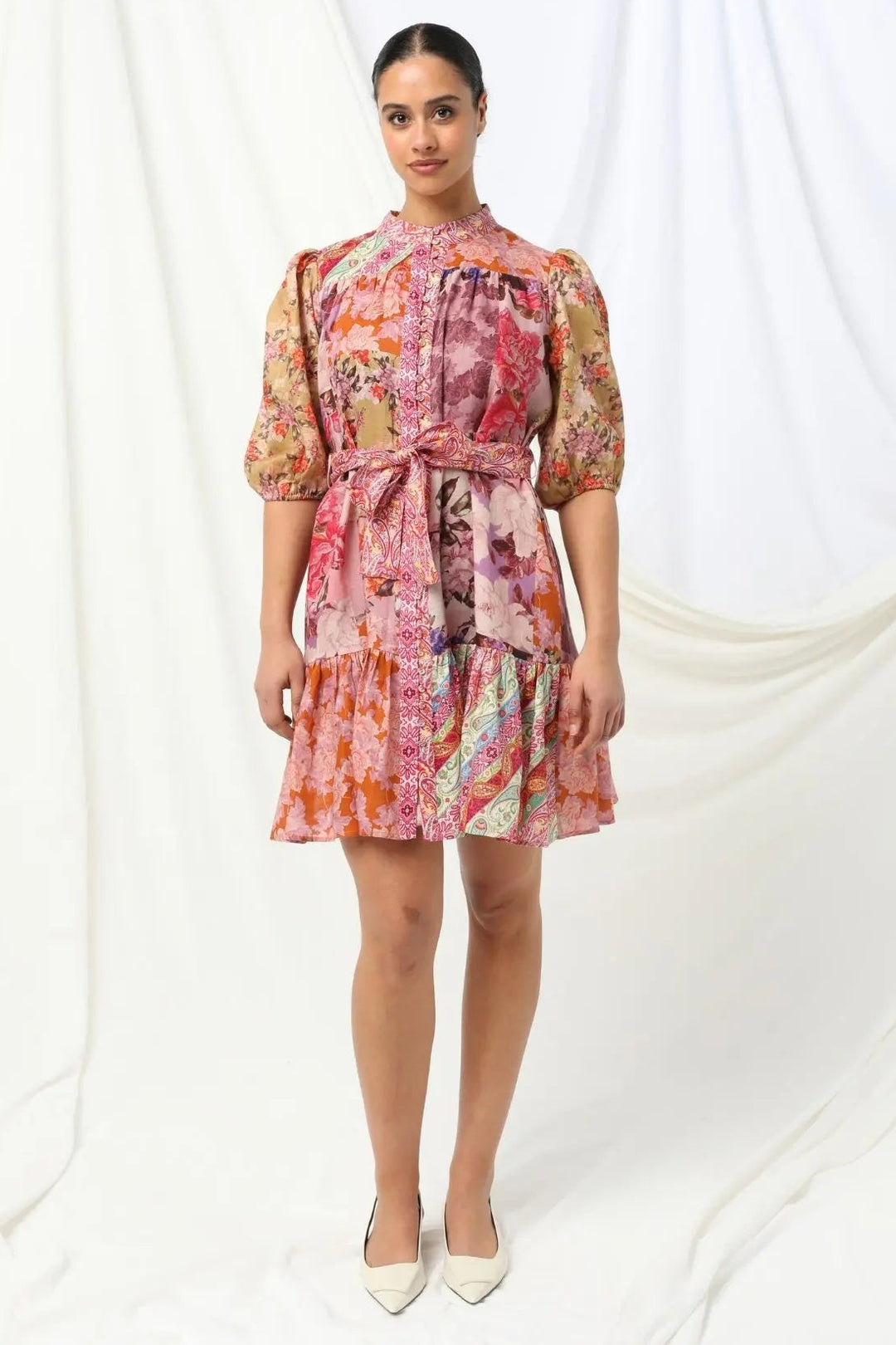 Woman wearing a colorful floral dress on a white background