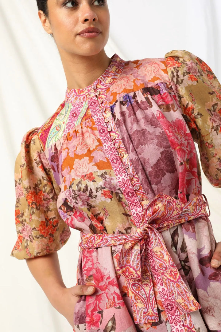 Woman wearing a colorful, patterned dress with a white background