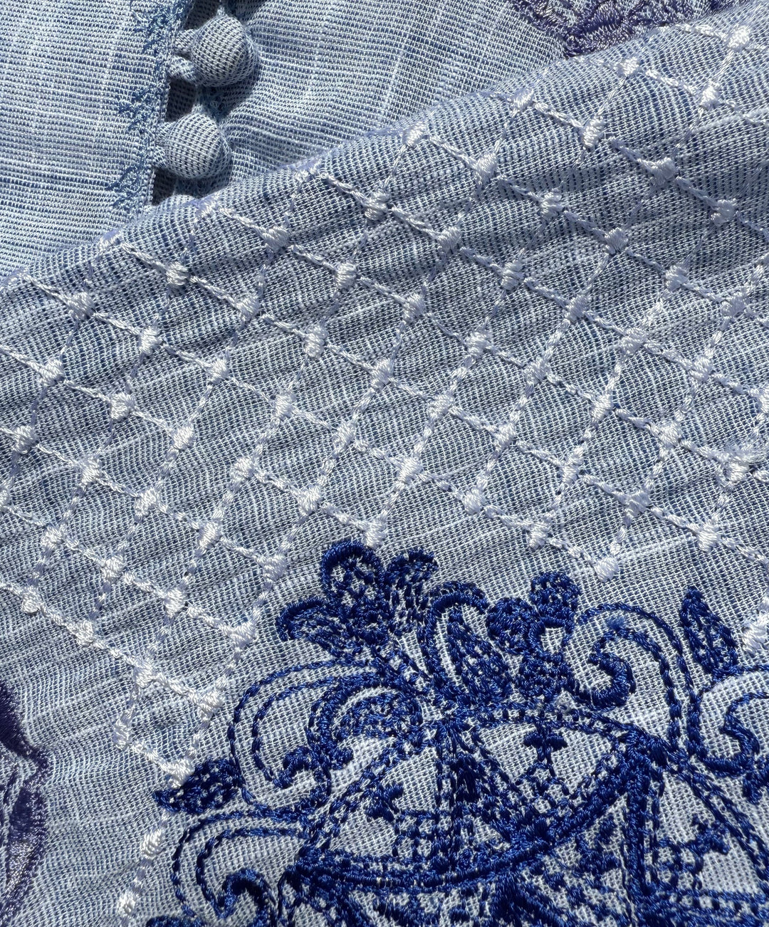 Close-up of blue embroidered fabric with intricate patterns