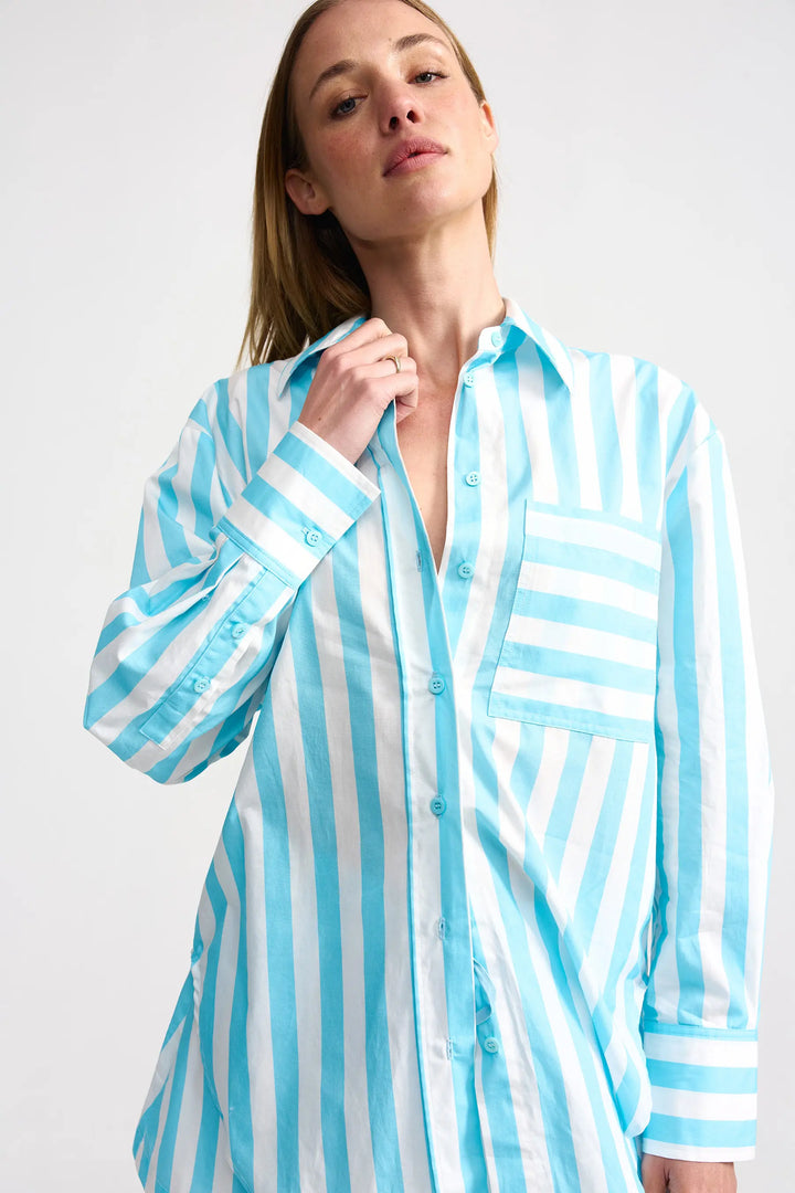 Woman wearing a blue and white striped shirt against a white background. Aston Studio Buddy Shirt Caribbean Stripe