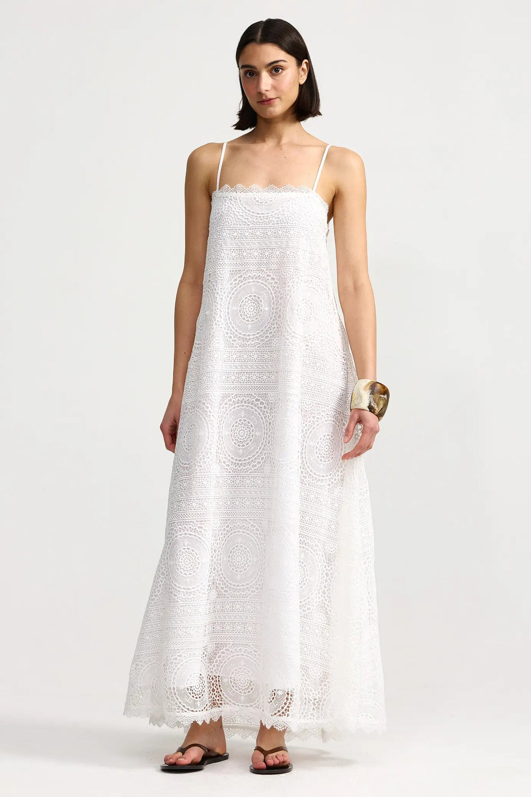 Woman wearing a white lace dress on a white background. Willow Dress Antique