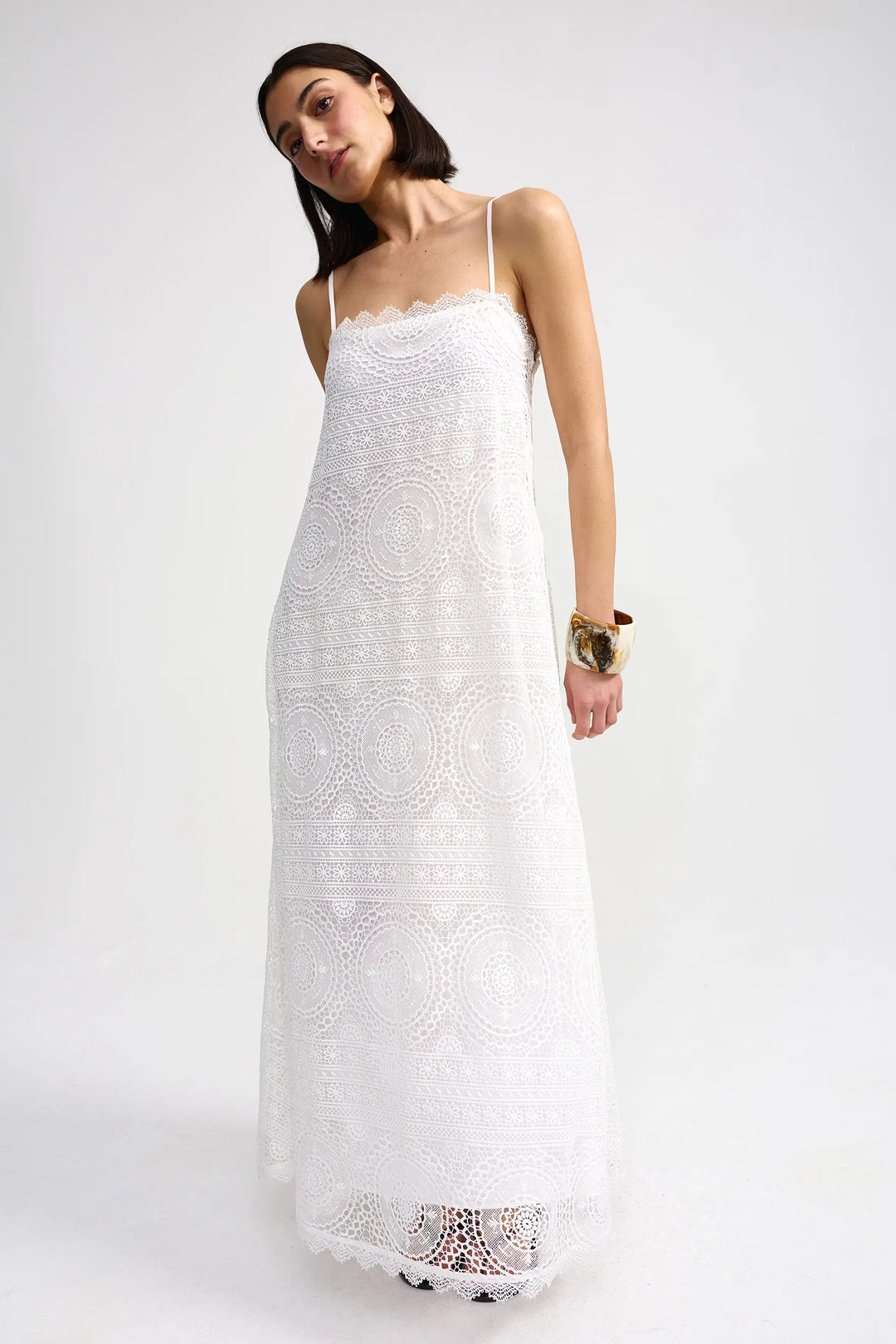 Woman wearing a white lace dress on a white background. Willow Dress Antique