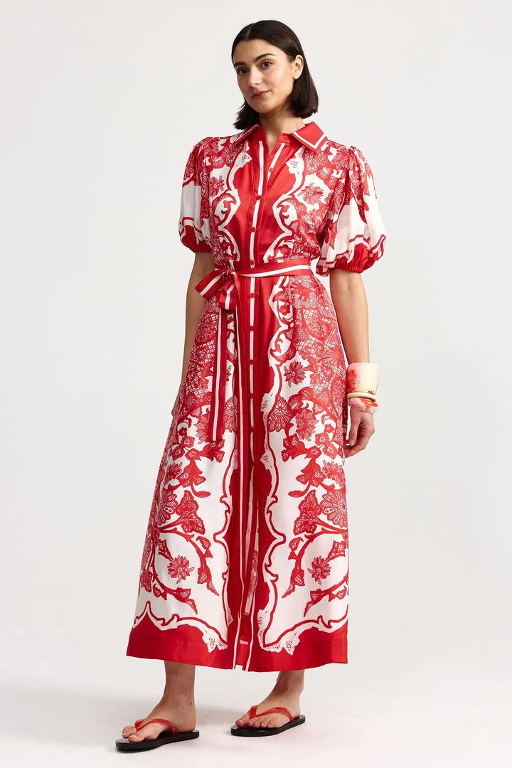 Woman wearing a red and white patterned dress on a white background