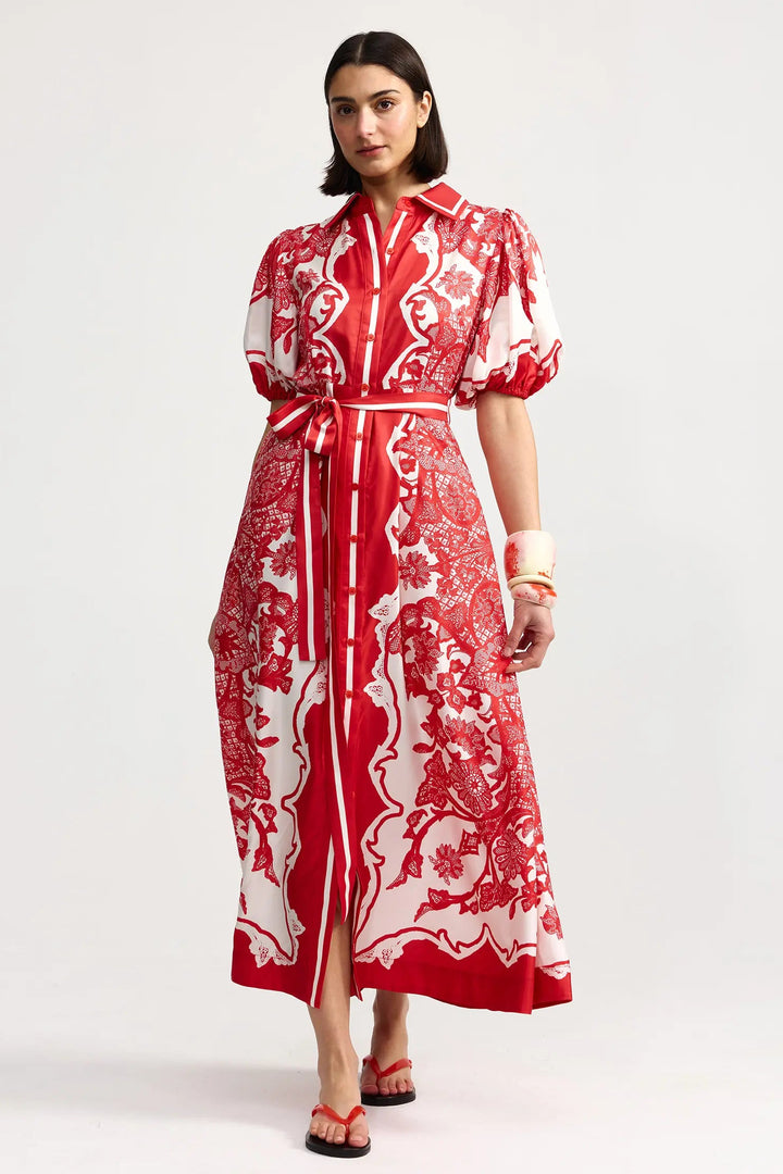Woman wearing a red and white patterned dress on a white background