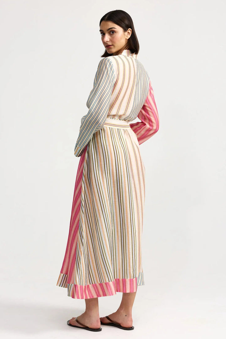 Woman wearing a colorful striped dress on a white background. Aston Studio Neotta Dress Peony Multi Stripe