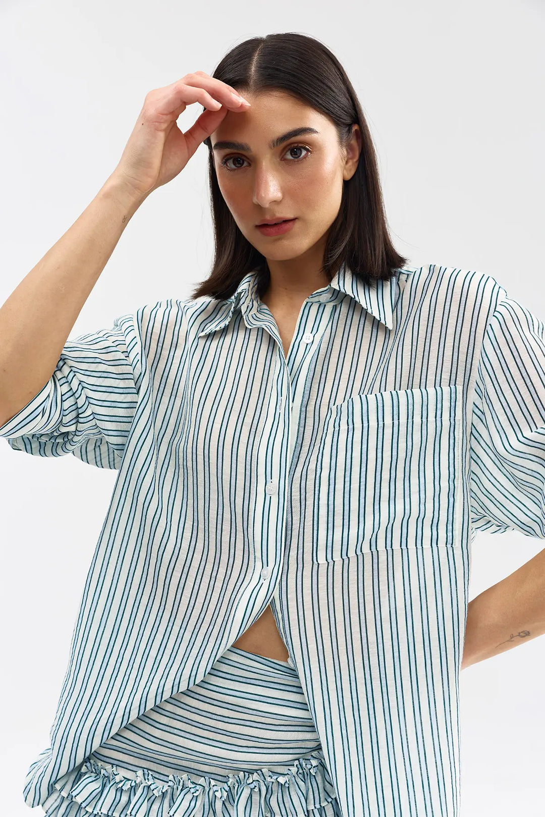 Woman wearing a striped shirt and skirt set on a white background