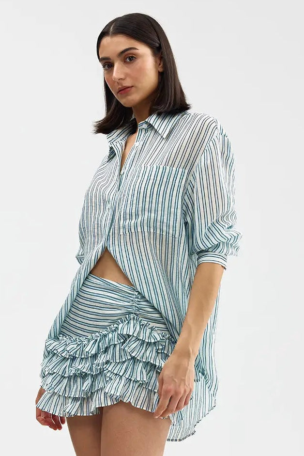 Woman wearing a striped shirt and ruffled skirt on a white background