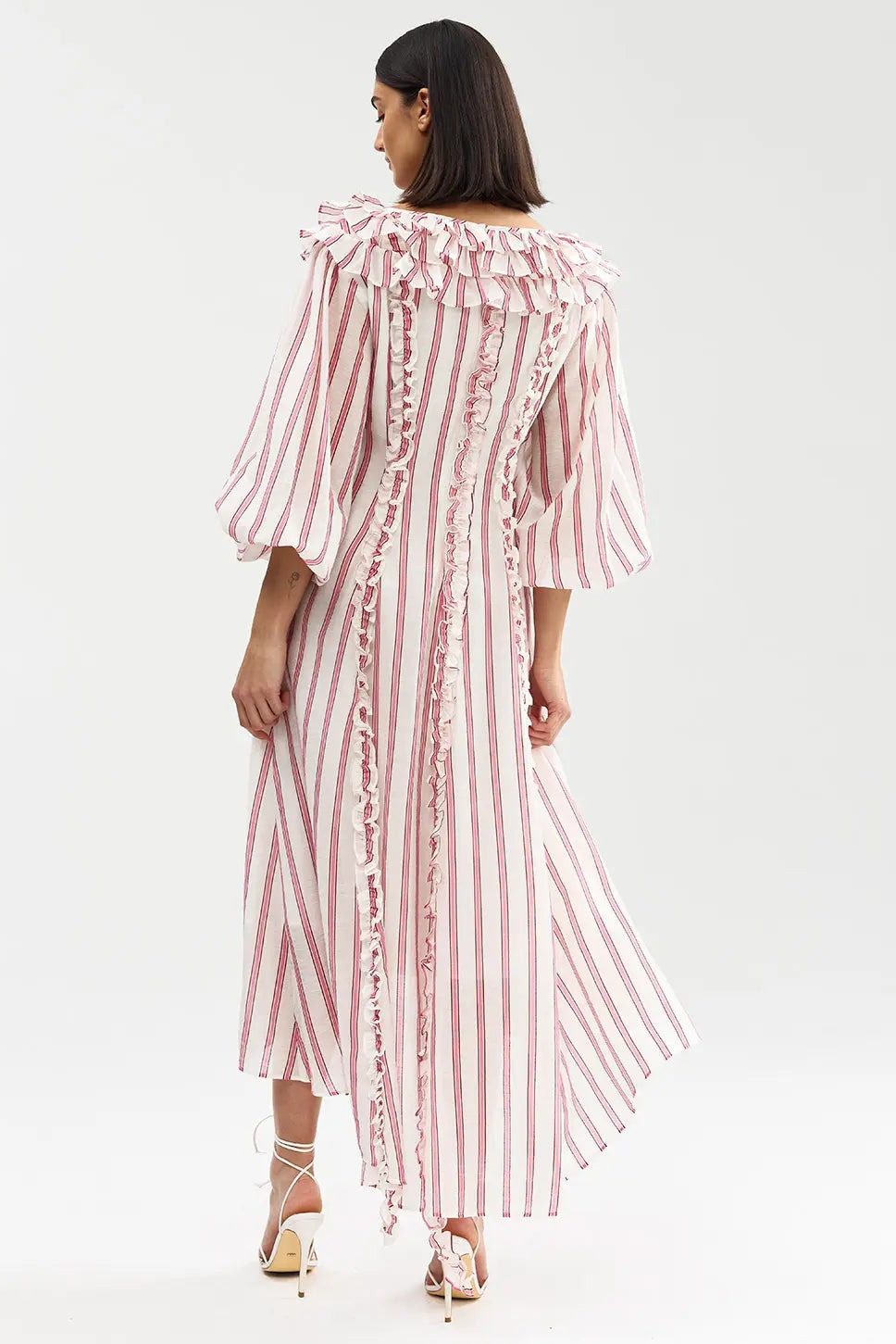 Woman wearing a pink and white striped dress on a white background
