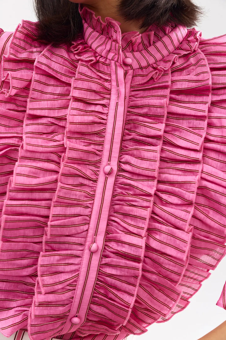 Close-up of a pink textured garment with buttons on a white background