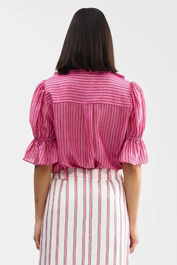 Woman wearing a pink and white striped dress on a white background