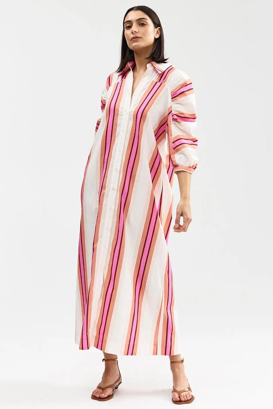 Woman wearing a long, striped dress on a white background