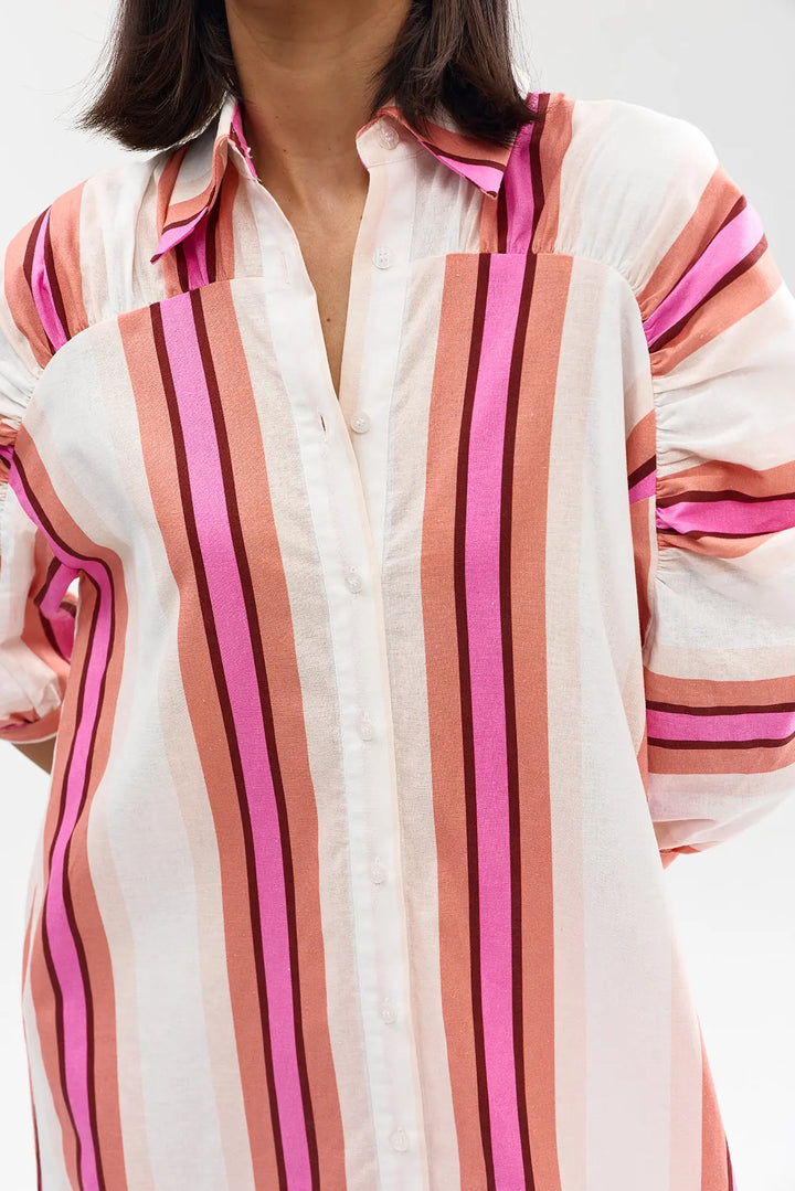 Close-up of a person wearing a striped shirt with pink and brown horizontal stripes on a white background.