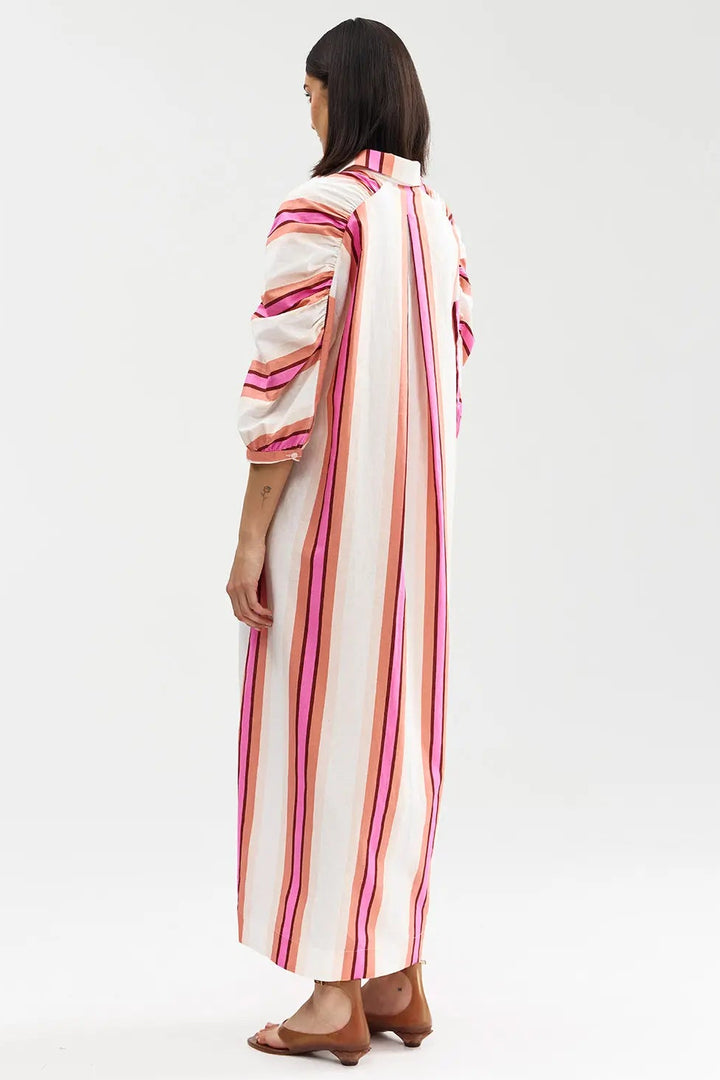 Woman wearing a long, striped dress on a white background