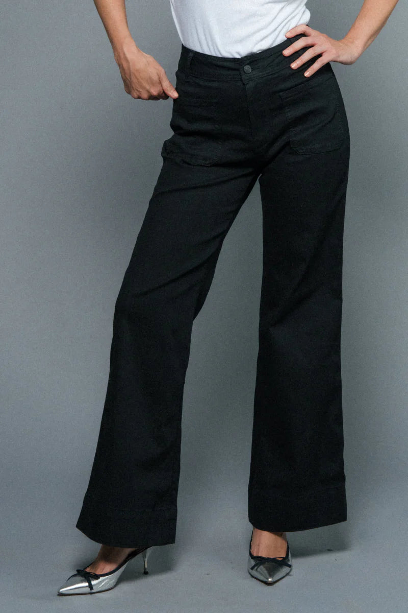 Person wearing black pants on a gray background