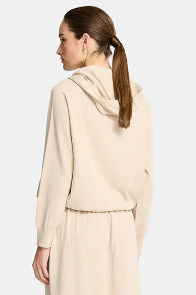 Woman wearing a beige coat with a white background