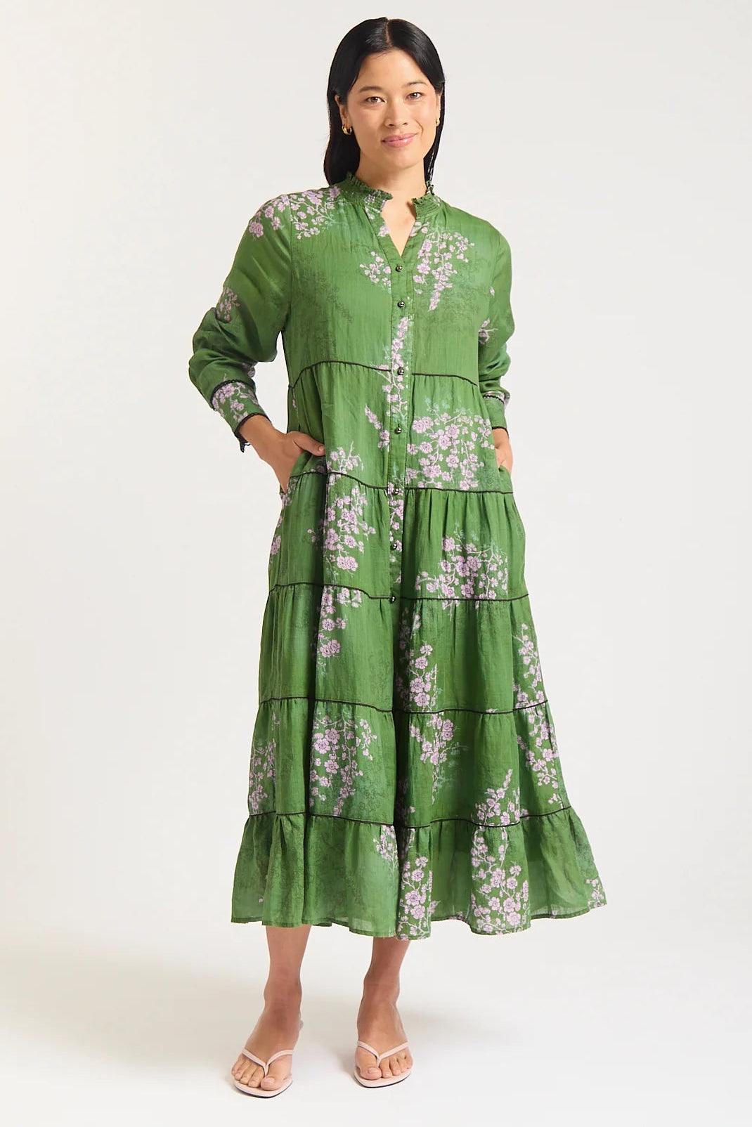Woman wearing a green floral dress on a white background
