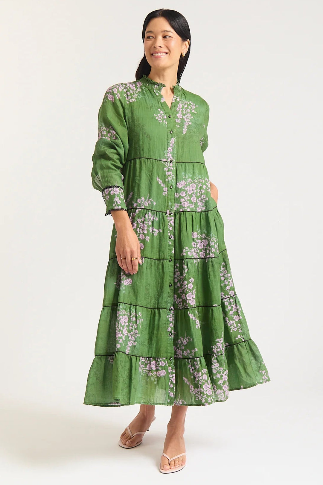 Woman wearing a green floral dress on a white background
