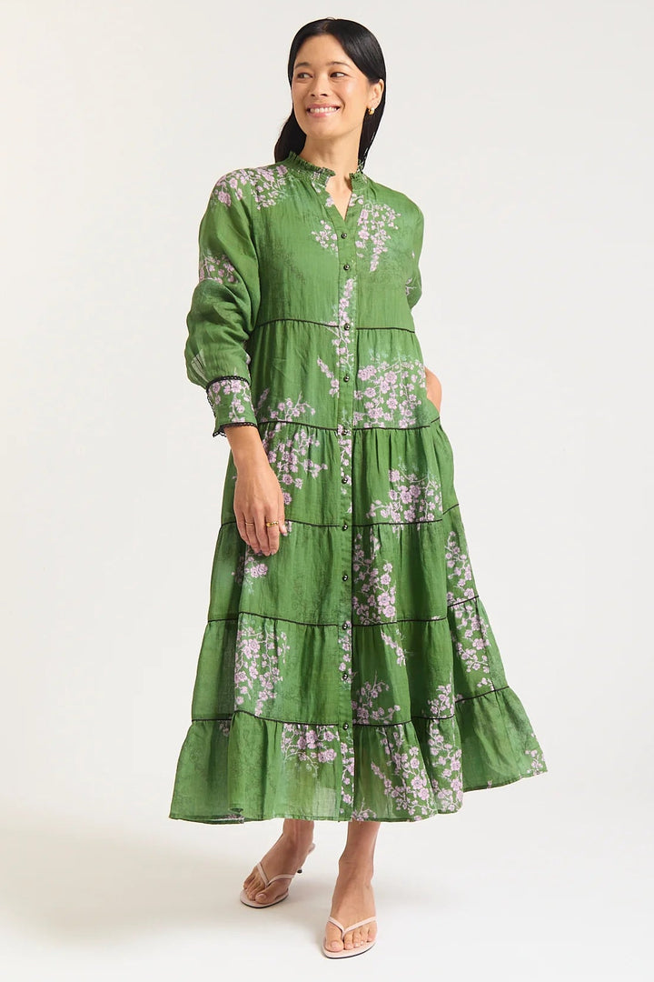 Woman wearing a green floral dress on a white background