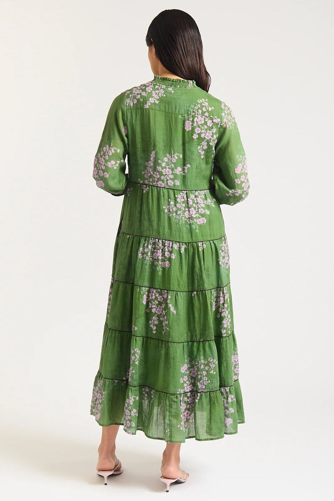 Woman wearing a green floral dress on a white background