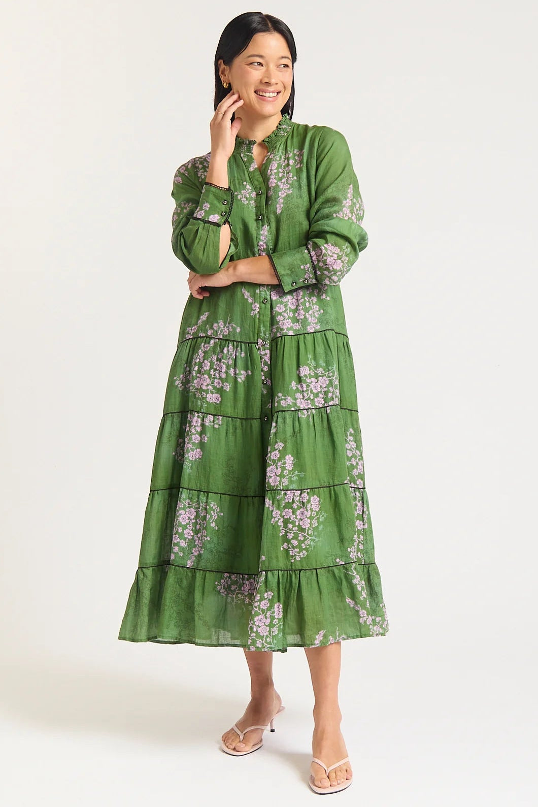 Woman wearing a green floral dress against a white background