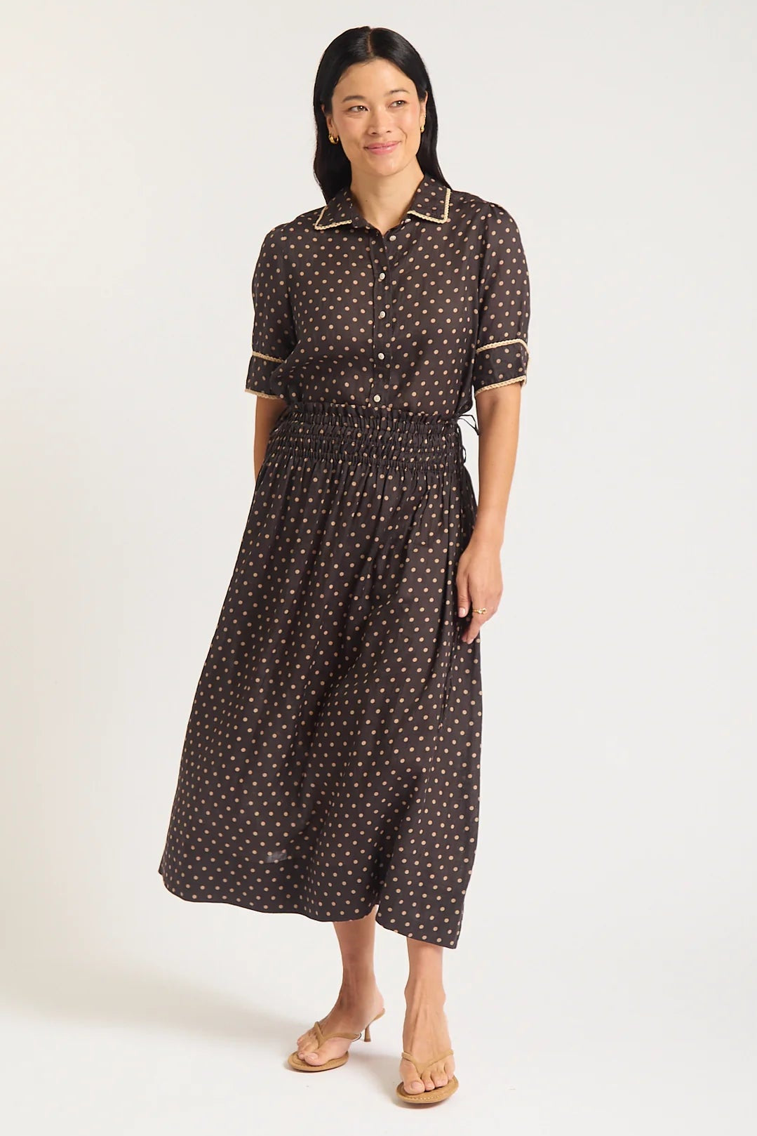 Woman wearing a black patterned dress on a white background