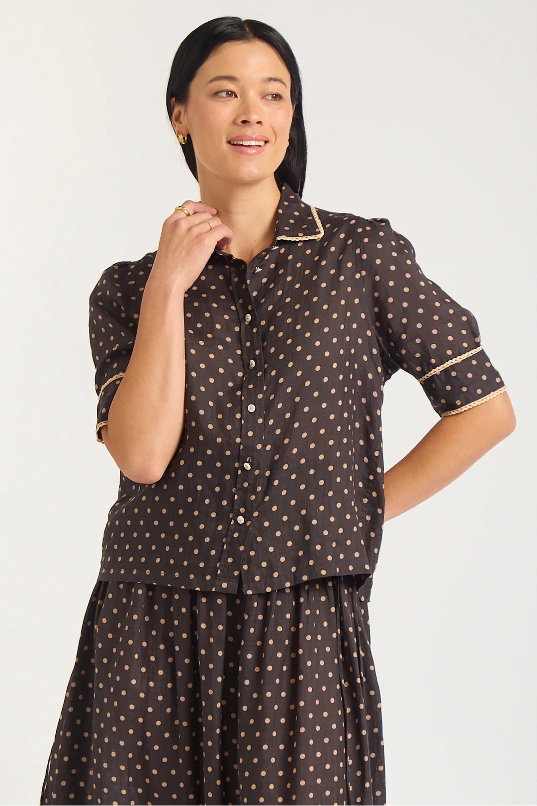 Woman wearing a brown polka dot dress on a white background