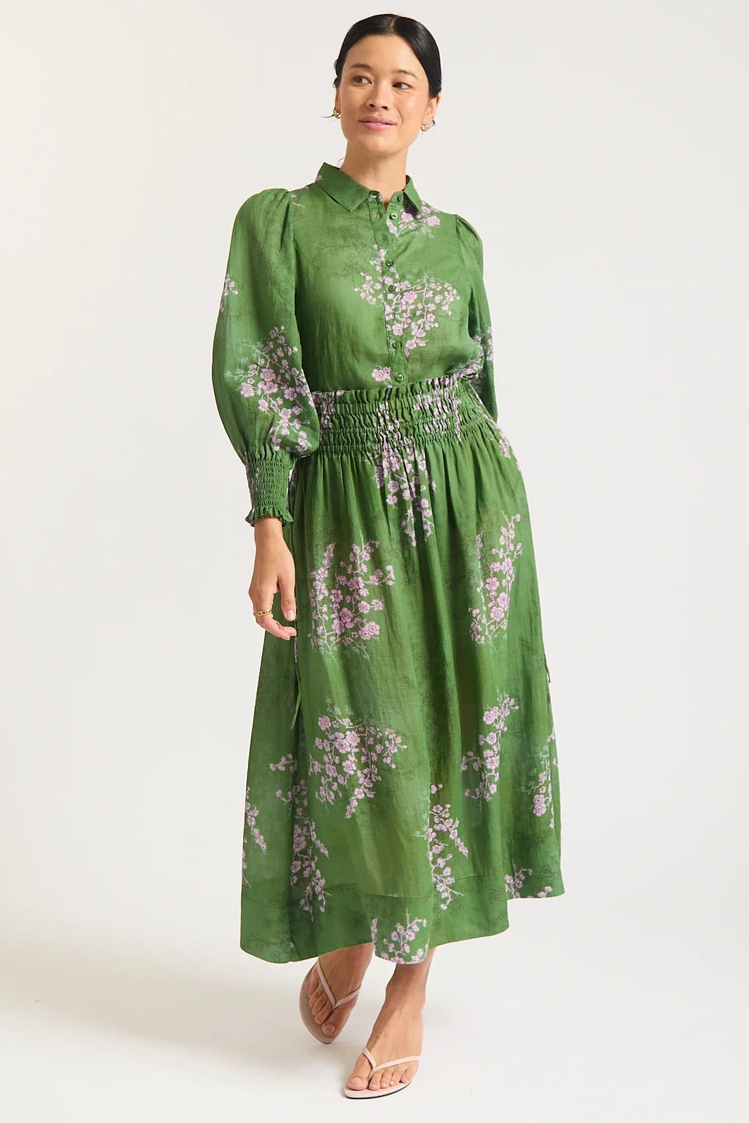 Woman wearing a green floral dress on a white background