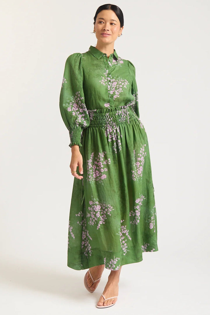 Woman wearing a green floral dress on a white background