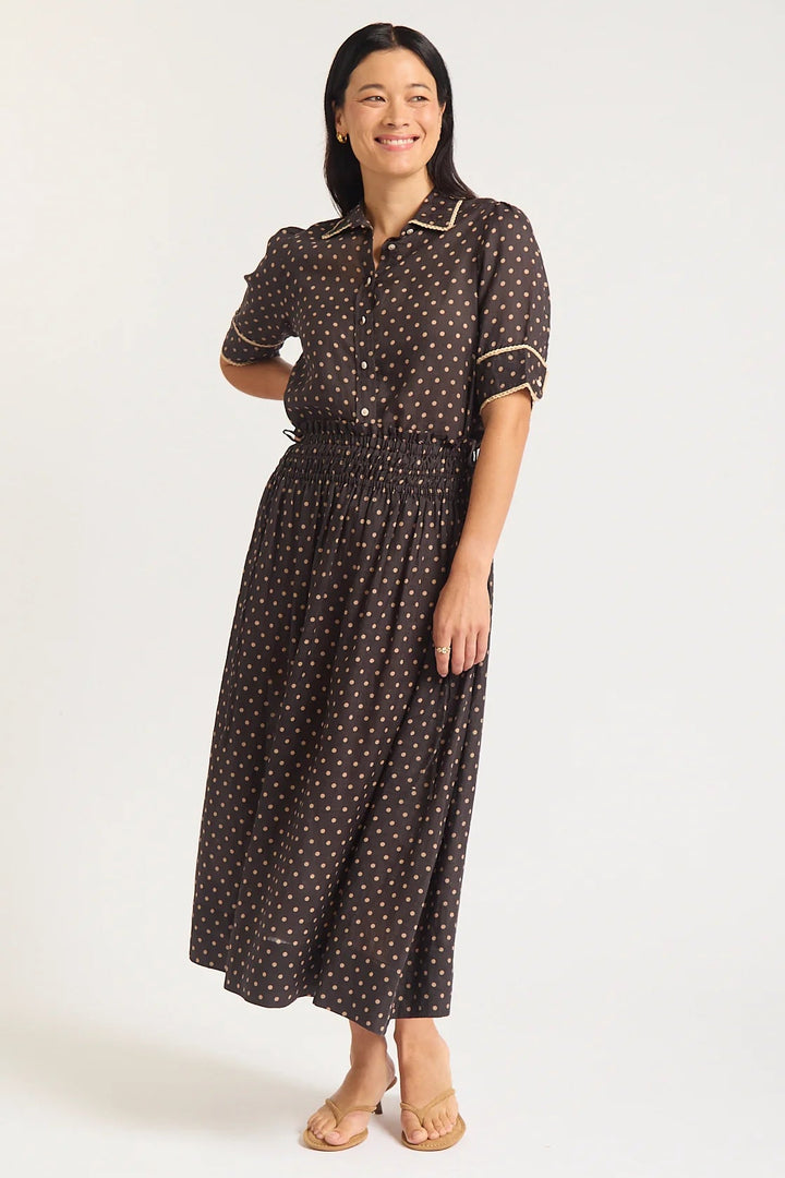 Woman wearing a black polka dot dress on a white background