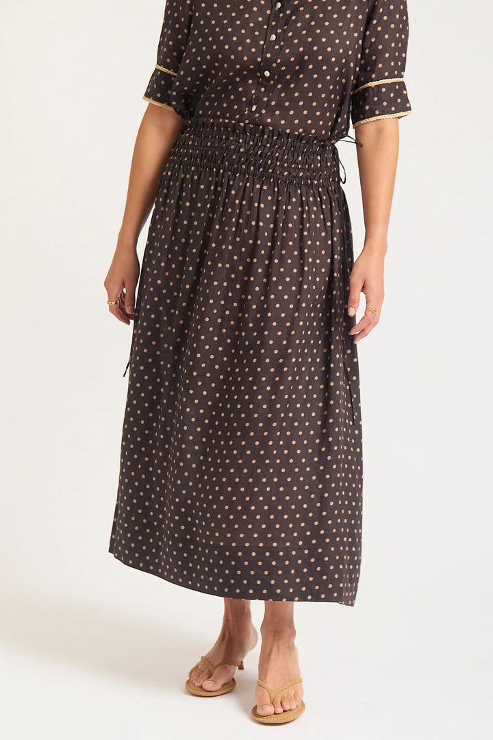 Woman wearing a black polka dot dress on a white background