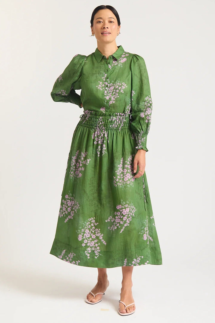 Woman wearing a green floral dress on a white background