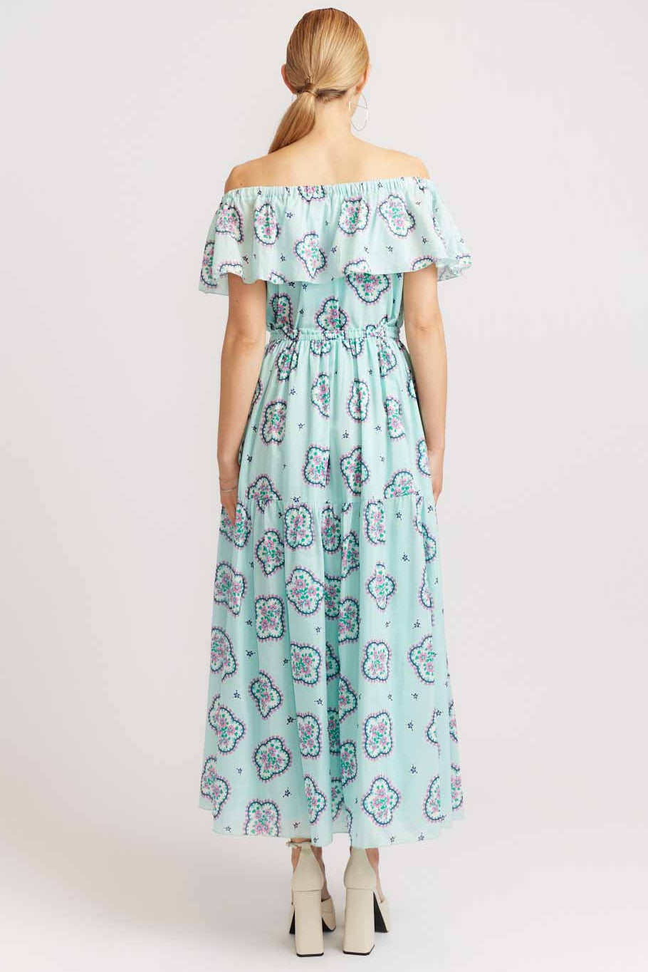 Woman wearing a floral off-shoulder dress on a white background