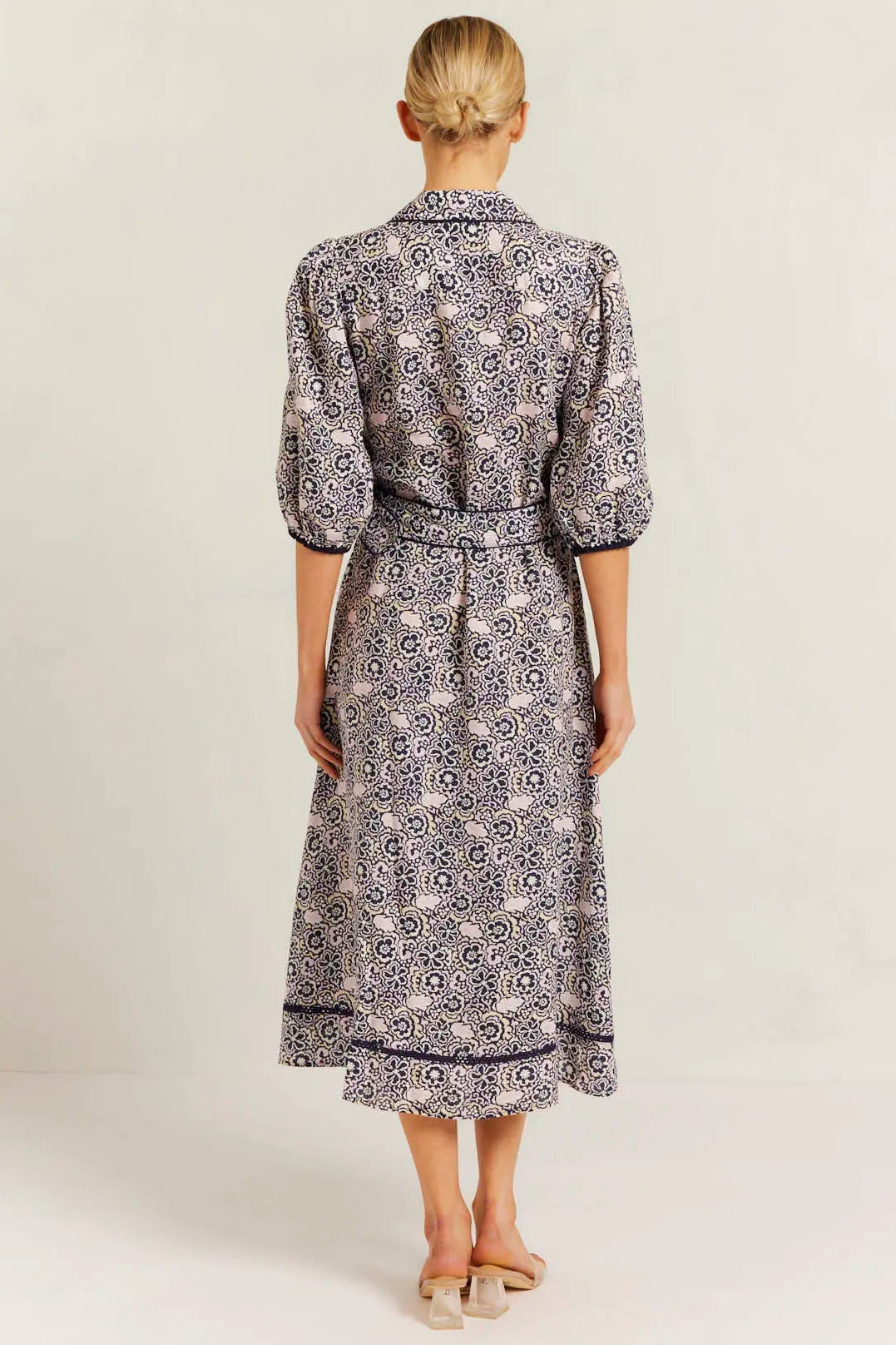 Woman wearing a patterned dress on a white background