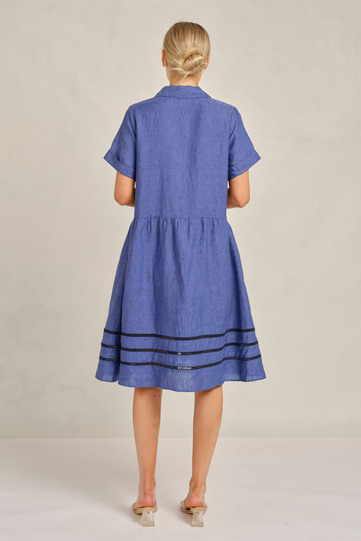 Woman wearing a blue dress with a plain background