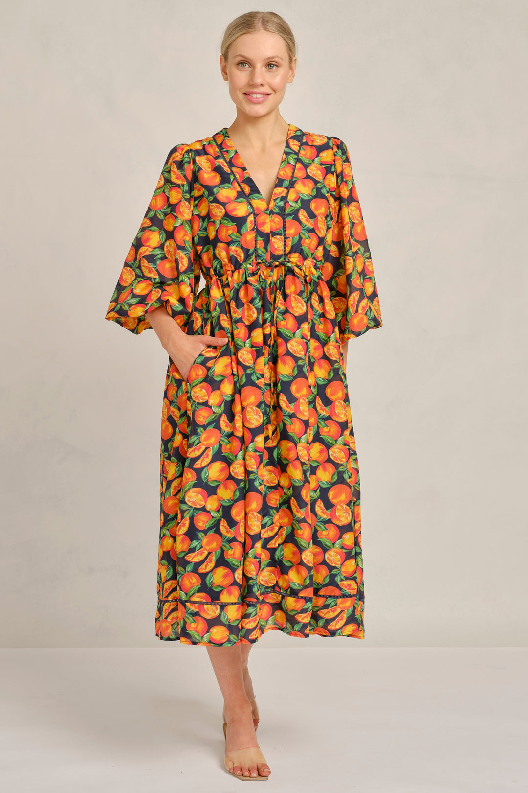 Woman wearing a patterned dress on a plain background