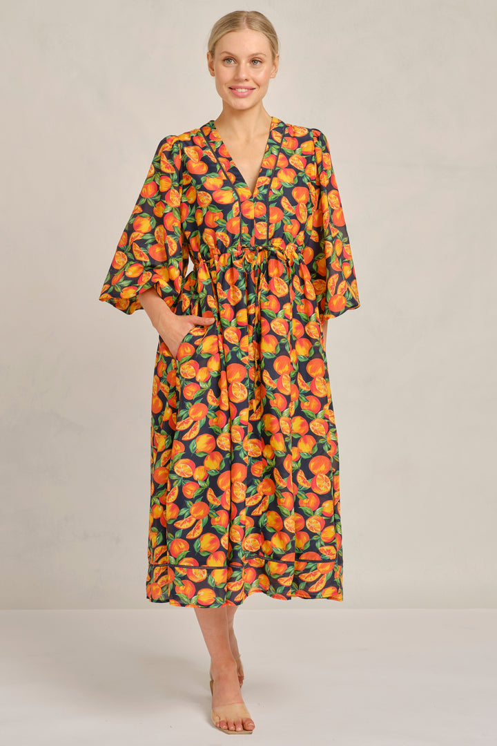 Woman wearing a patterned dress on a plain background