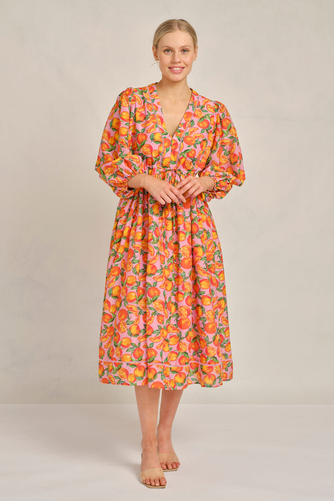 Woman wearing a floral dress against a plain background