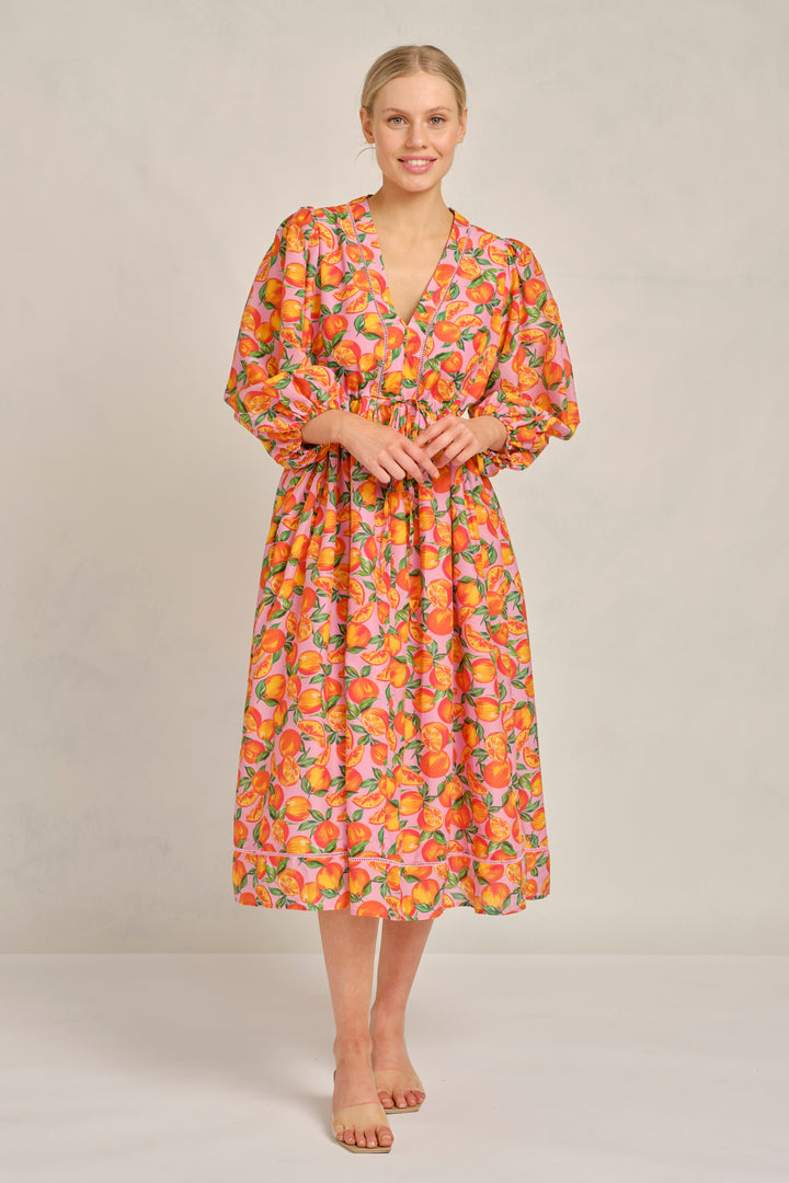 Woman wearing a floral dress against a plain background