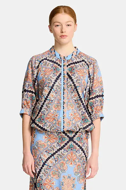 Woman wearing a patterned outfit on a white background