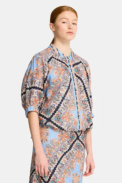 Woman wearing a patterned outfit on a white background