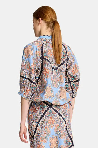 Woman wearing a patterned dress on a white background