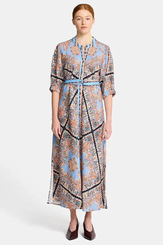Woman wearing a patterned dress on a white background