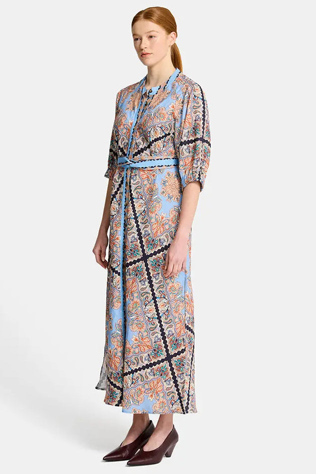 Woman wearing a patterned dress on a white background