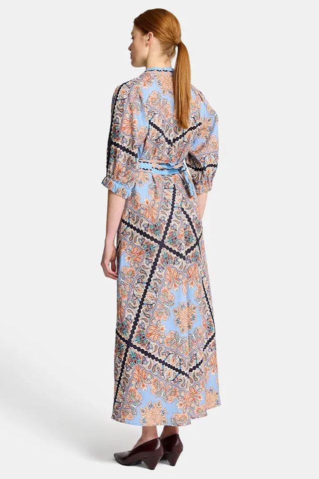 Woman wearing a floral dress with a belt on a white background