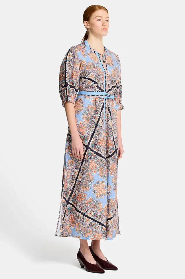 Woman wearing a floral dress with a belt on a white background