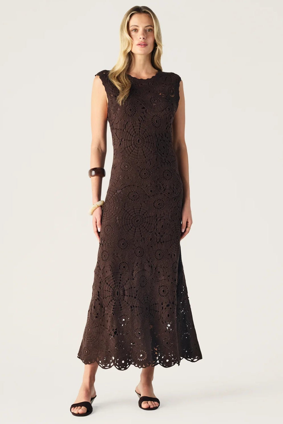 Woman wearing a brown lace dress on a white background