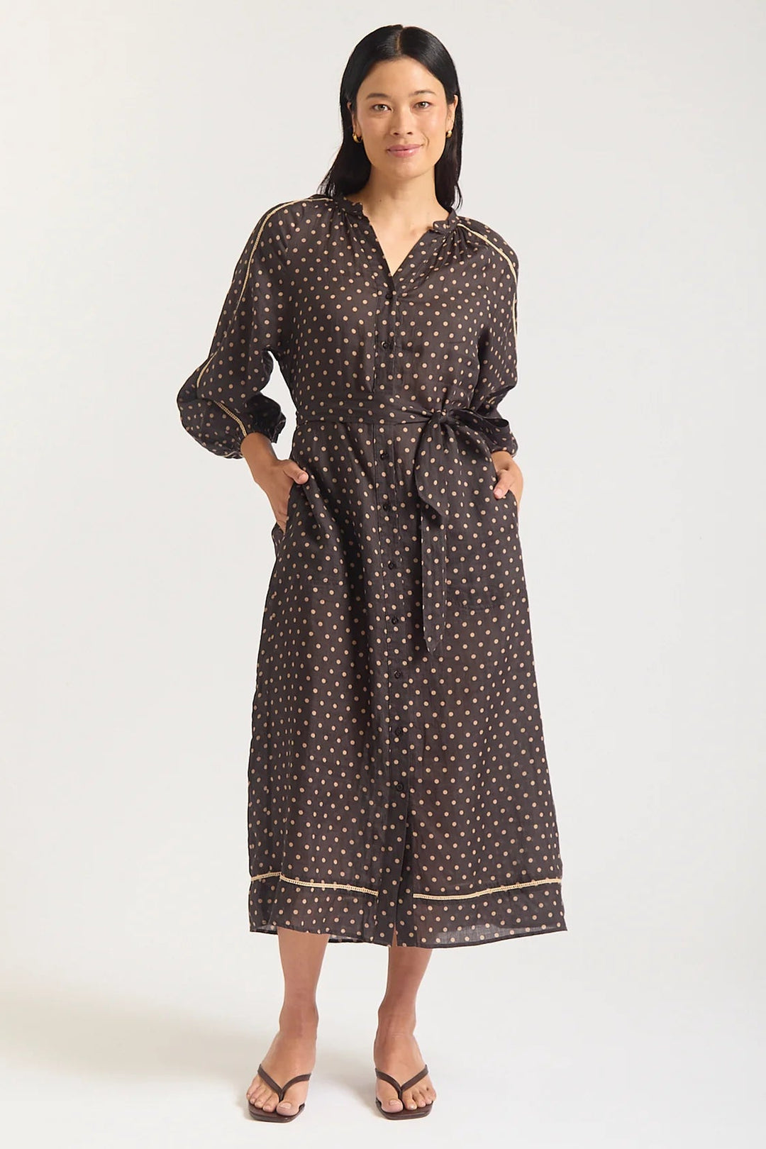 Woman wearing a brown patterned dress on a white background