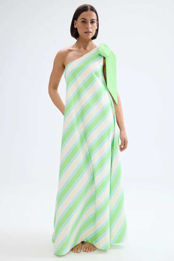 Woman wearing a green and white striped one-shoulder dress on a white background. Aston Studio Mila Dress Fern Lapis Stripe