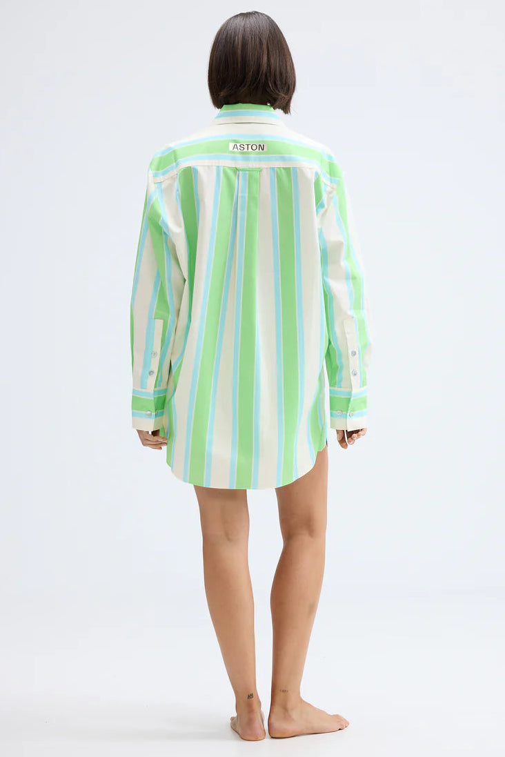 Person wearing a green and white striped shirt on a white background. Aston Studio Buddy Shirt Fern Lapis Stripe 