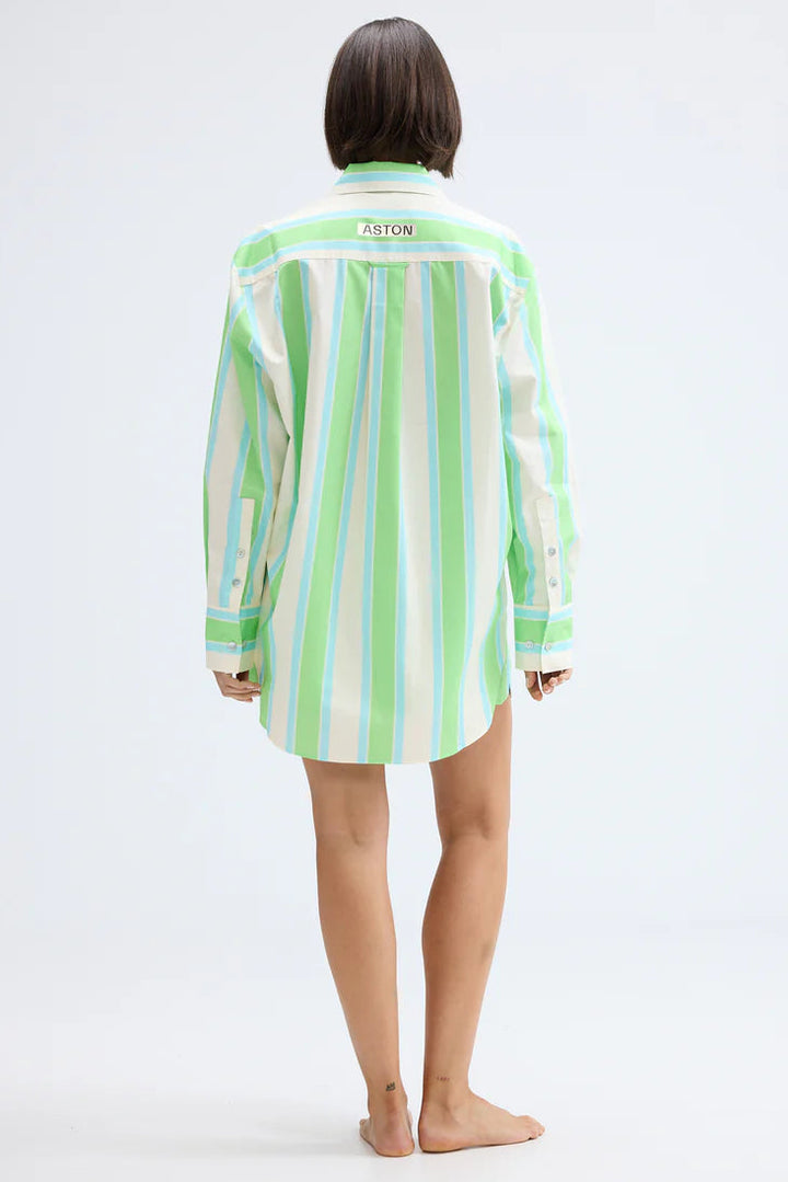 Person wearing a green and white striped shirt on a white background. Aston Studio Buddy Shirt Fern Lapis Stripe 